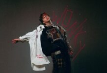 NOAHFINNCE annonce « WONKY », son nouvel album pour février 2027 NOAHFINNCE, en tenue bricolée et chemise blanche, pose les bras écartés devant un fond sombre, avec le titre « WONKY » tracé en rouge