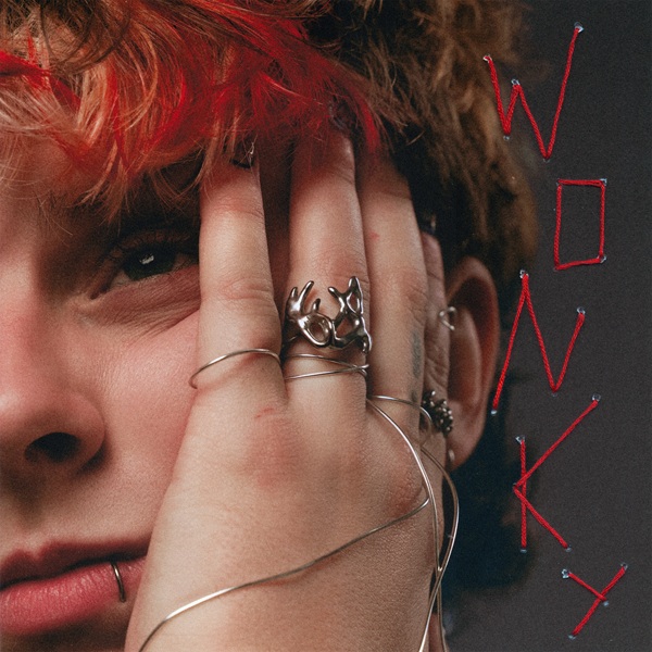 Pochette du single « Wonky » : une main aux bagues argentées et le titre écrit au fil rouge