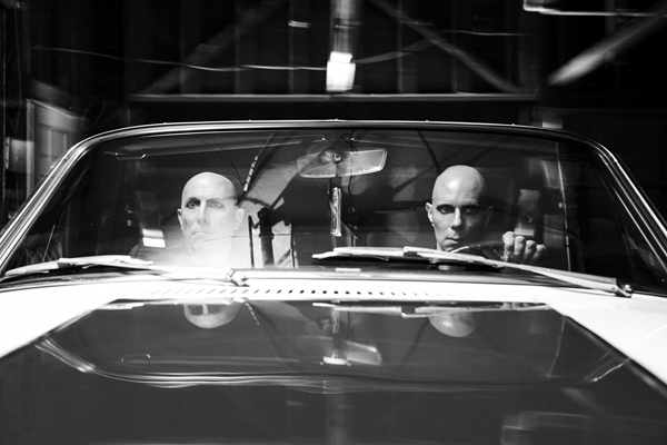 Maynard James Keenan et Billy Howerdel, en noir et blanc, assis dans une voiture