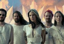Charlotte Wessels annonce Mute Swan Empire, un album conceptuel Charlotte Wessels et les membres de The Obsession posant devant un fond de cristaux stylisés et de ciel orangé