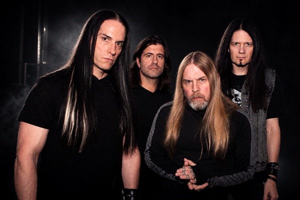 Portrait de groupe de SOiL, quatre musiciens en noir sur fond sombre