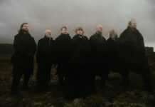 Wardruna dévoile « Helvegen II », une nouvelle version bouleversante Les membres de Wardruna, vêtus de noir, debout dans une lande brumeuse