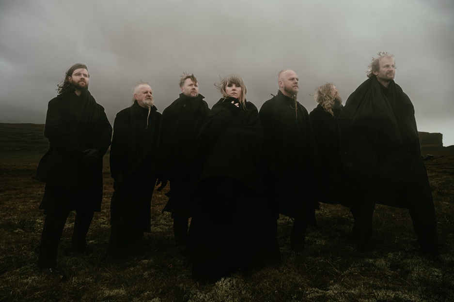 Les membres de Wardruna, vêtus de noir, debout dans une lande brumeuse