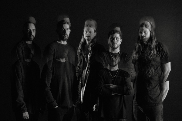 Les membres de Currents posant en noir et blanc sur fond sombre