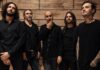 Klone dévoile « Unchained », premier extrait de The Moon Is Witness Portrait des cinq membres du groupe Klone, vêtus de noir, devant un mur en bois