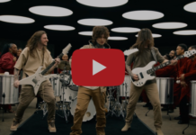 Polyphia sort « Be Not Afraid », entre metal, prog et house Quatre musiciens en guitare, entourés de percussionnistes en tenue rouge dans un décor de studio aux plafonds ronds lumineux