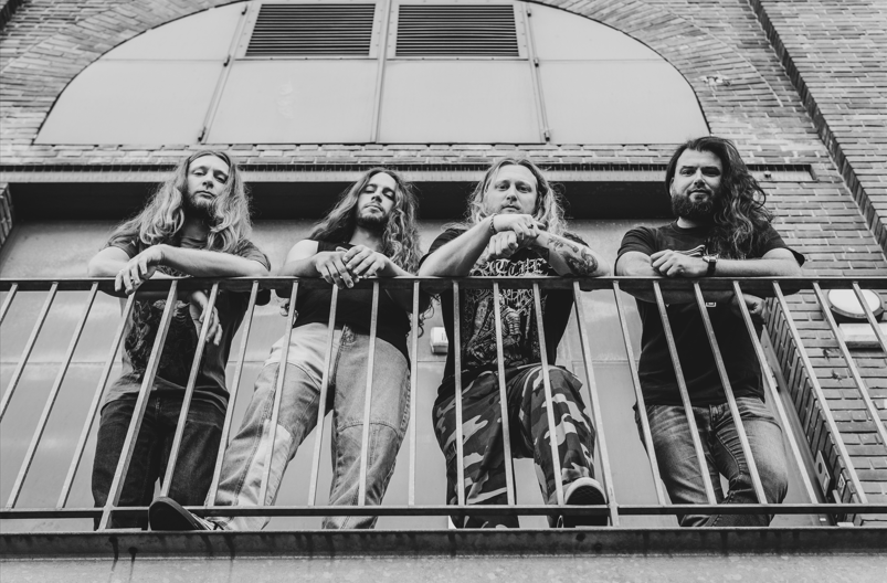 Les quatre membres de Gates of Autricon accoudés à un balcon en noir et blanc