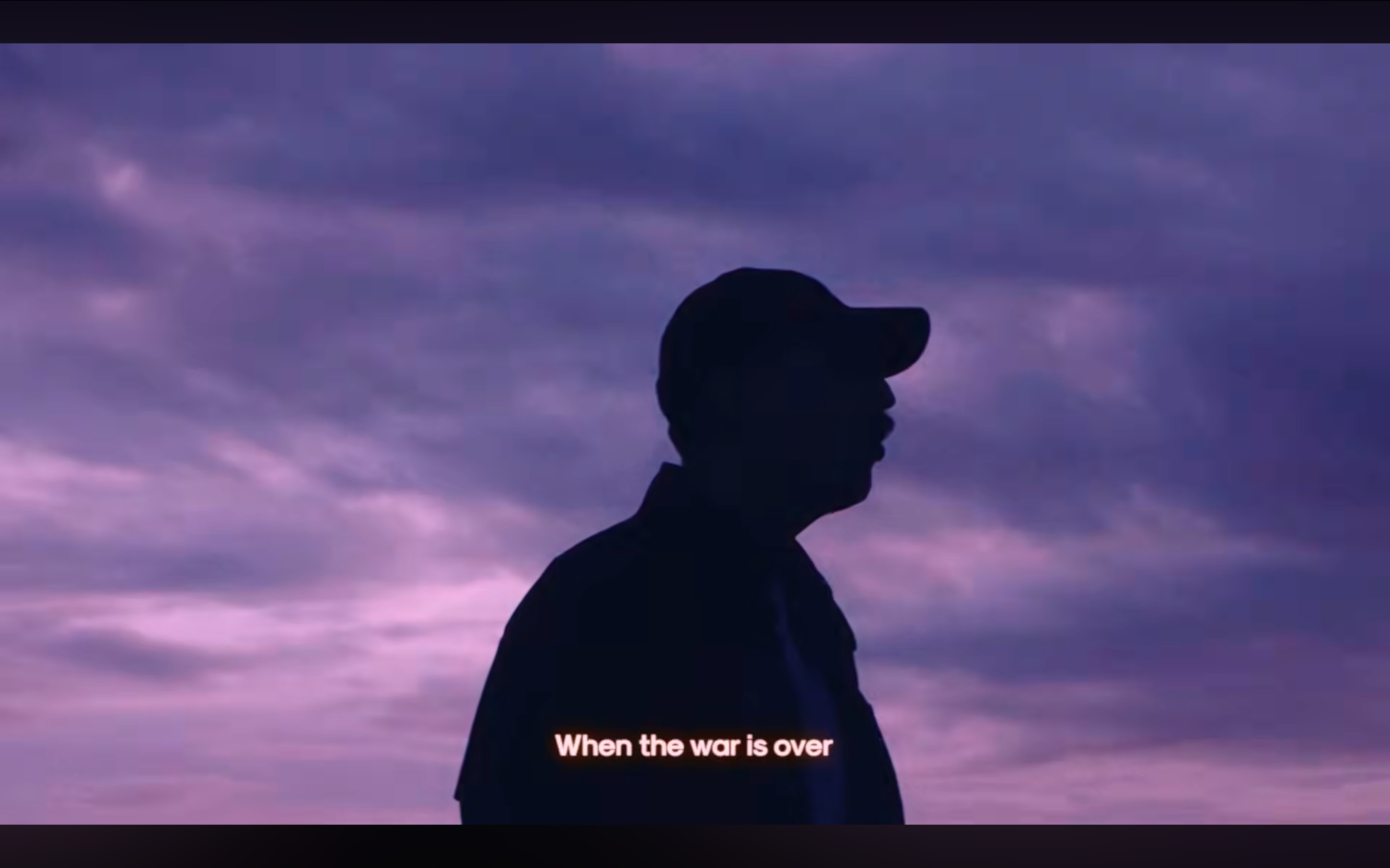 Plan du clip « When The War Is Over » : silhouette d'un homme casquette sur fond de ciel violet