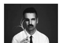 Kabbel sort « When The War Is Over », son premier album Portrait en noir et blanc de Kabbel, un homme en chemise blanche et cravate noire, un cache sur un œil et une tige végétale à la main