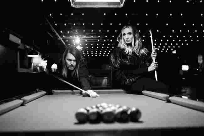 Russell Marsden et Iona Alven de Band of Skulls jouant au billard, en noir et blanc