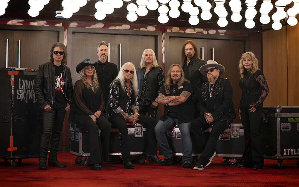 Photo de groupe des membres de Lynyrd Skynyrd posés sur des flight cases